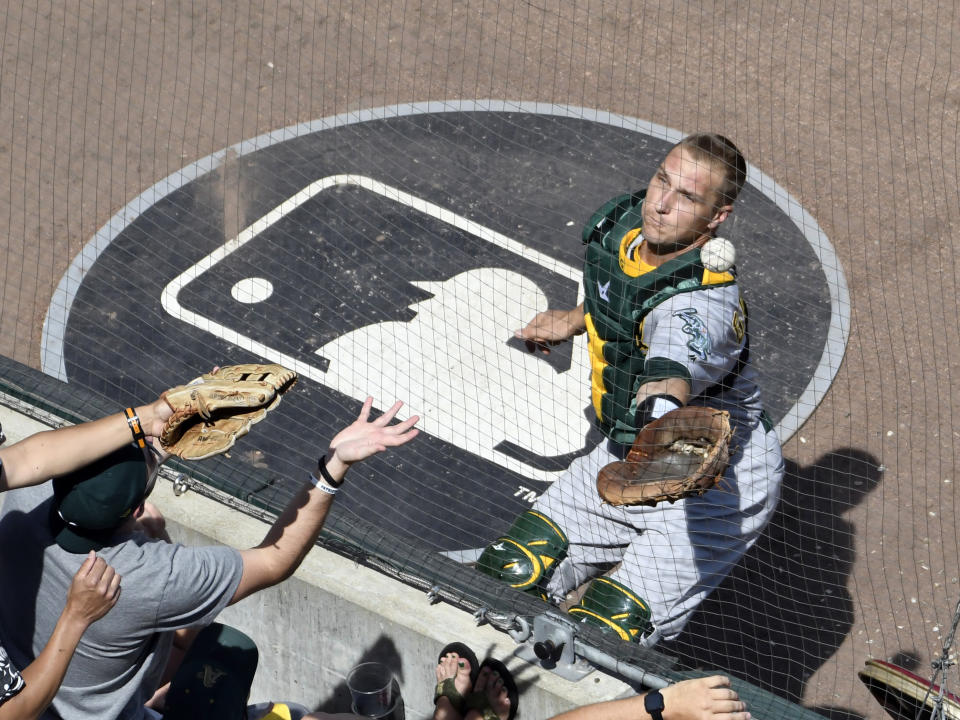 Oakland Athletics catcher Dustin Garneau, right, cannot make a catch on a hit by Chicago White Sox's Ryan Cordell during the third inning of a baseball game, Friday, Aug. 9, 2019, in Chicago. (AP Photo/David Banks)