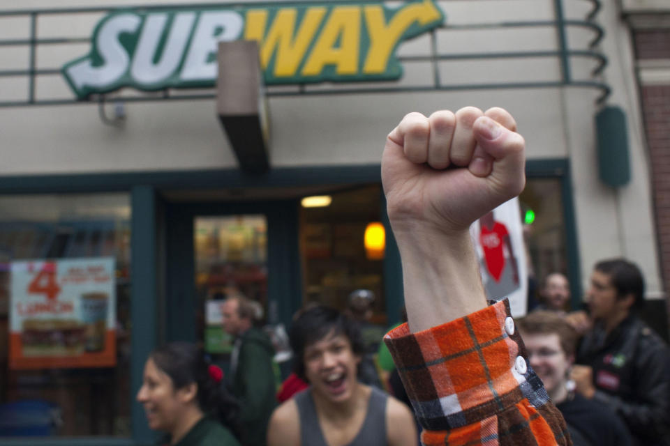 Stephen Baldwin holds his fist in the air outside a Subway restaurant during a strike aimed at the fast-food industry and the minimum wage in Seattle, Washington August 29, 2013. Fast-food workers went on strike and protested outside restaurants in 60 U.S. cities on Thursday, in the largest protest of an almost year-long campaign to raise service sector wages. REUTERS/David Ryder (UNITED STATES - Tags: CIVIL UNREST BUSINESS FOOD EMPLOYMENT)