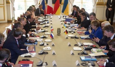 General view of German Chancellor Angela Merkel (4thR) and Ukraine's President Petro Poroshenko (5thR) who sit at the table across from Russian President Vladimir Putin (5thL) and French President Francois Hollande (6thL) during a summit on Ukraine at the Elysee Palace in Paris, France, October 2, 2015. REUTERS/Etienne Laurent/Pool