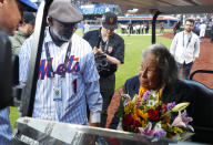 Former New York Mets Mookie Wilson, left, presents Rachel Robinson with flowers in honor of Jackie Robinson Day before a baseball game between the Mets and the Pittsburgh Pirates Monday, April 15, 2024, in New York. (AP Photo/Noah K. Murray)