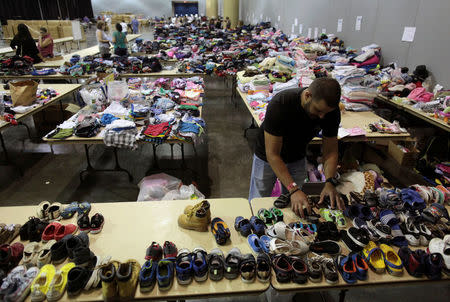 Volunteers sort donated shoes and clothes for Caribbean refugees whose homes were destroyed by Hurricane Irma, at a convention centre in San Juan, Puerto Rico September 14, 2017. REUTERS/Alvin Baez