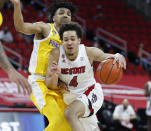 N.C. State's Jericole Hellems (4) drives by Pittsburgh's Ithiel Horton (0) during the first half of an NCAA college basketball game in Raleigh, N.C., Sunday, Feb. 28, 2021. (Ethan Hyman/The News & Observer via AP)