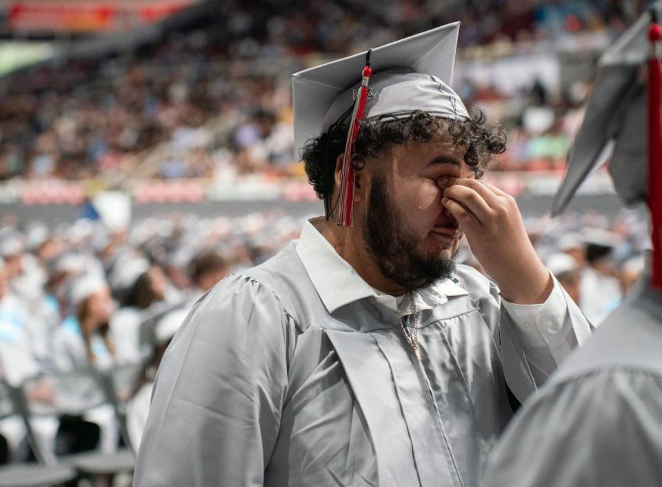 A David W. Butler High School graduate wipes his eyes before walking onto the stage to receive his diploma at the Bojangles Coliseum in Charlotte on Monday, June 10, 2024.