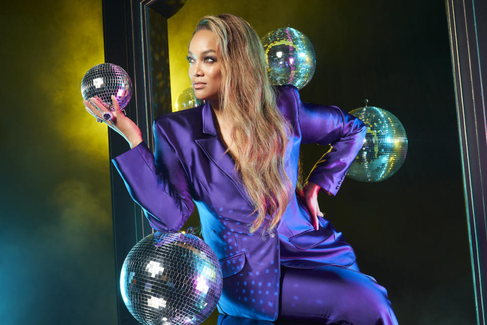 Tyra Banks wearing purple suit.