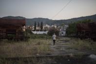 Un hombre paseo junto a una antigua estación de tren abandonada de la era comunista en Ballsh. (Foto: Daniel Cole / AP).