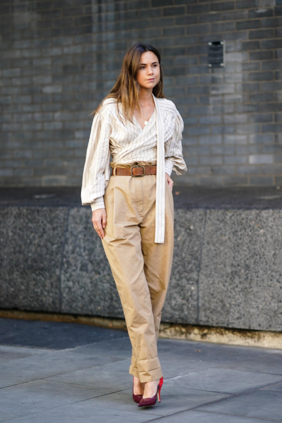 A guest is seen wearing high waisted brown trousers and a striped shirt. [Photo: Getty Images]