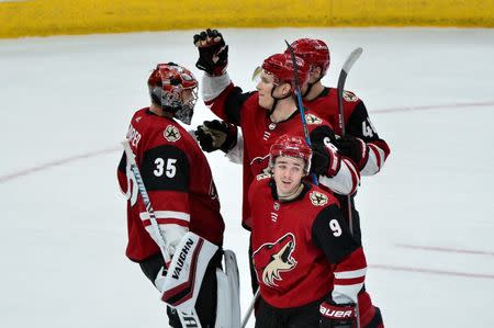 Feb 28, 2019; Glendale, AZ, USA; Arizona Coyotes goaltender Darcy Kuemper (35) celebrates with center Clayton Keller (9), defenseman Jakob Chychrun (6) and defenseman Ilya Lyubushkin (46) after defeating the Vancouver Canucks at Gila River Arena. Mandatory Credit: Matt Kartozian-USA TODAY Sports