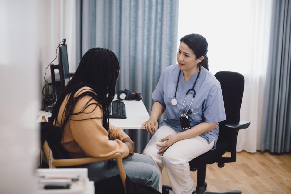 a young person talking to a doctor in an office