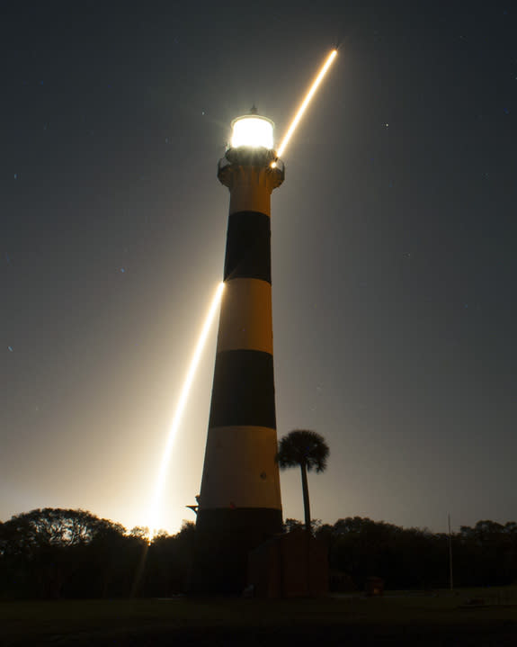 The United Launch Alliance Atlas V 401 rocket carrying NASA's Tracking and Data Relay Satellite-K, TDRS-K, streaks past the lighthouse on Cape Canaveral Air Force Station in Florida after launching from Space Launch Complex 41 at 8:48 p.m. EST