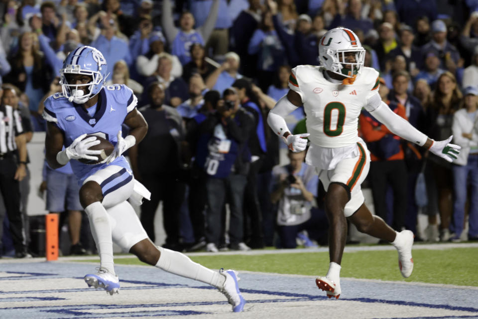 North Carolina wide receiver Devontez Walker (9) hauls in a touchdown pass against Miami cornerback Te'Cory Couch (0) during the first half an NCAA college football game Saturday, Oct. 14, 2023, in Chapel Hill, N.C. (AP Photo/Chris Seward)