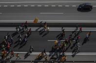 Demonstrators a long a road near Navas, Spain, Wednesday, Oct. 16, 2019. Thousands of people have joined five large protest marches across Catalonia that are set to converge on Barcelona, as the restive region reels from two straight days of violent clashes between police and protesters. The marches set off from several Catalan towns and aimed to reach the Catalan capital by Friday. (AP Photo/Bernat Armangue)