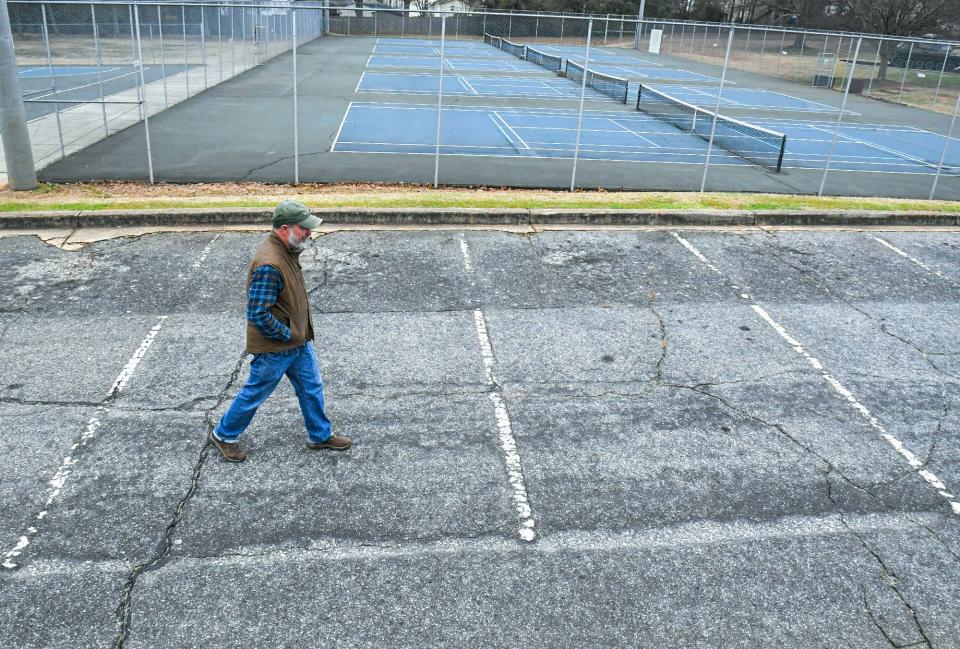Steve Thomason of Greenville, walks through an aged parking lot near basketball and tennis courts in Gower Park in Greenville, S.C. Tuesday, January 31, 2023.  Thirteen recreation projects in South Carolina were the recipients of federal Land and Water Conservation Fund (LWCF) grants, including $500,000 of the $1,400,000 project at Gower Park to renovate tennis and basketball courts, parking, and add new basketball, pickleball, and tennis courts. 