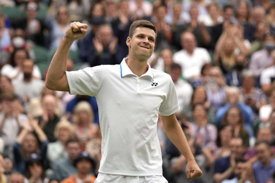 Poland's Hubert Huekacz celebrates after defeating Russia's Daniil Medvedev during the men's singles fourth round match on day eight of the Wimbledon Tennis Championships in London, Tuesday, July 6, 2021. (AP Photo/Kirsty Wigglesworth)