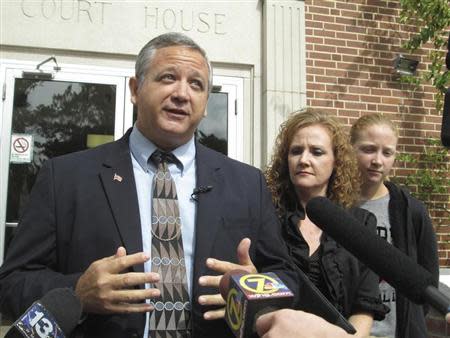 Suspended Liberty County Sheriff Nick Finch, with his wife Angela (C) and daughter Amber (R), talks with reporters on the steps of the courthouse after his acquittal on charges of official misconduct and falsifying official documents in Tallahassee, Florida October 31, 2013. REUTERS/Bill Cotterell