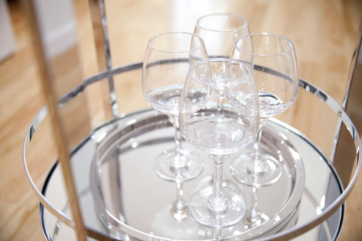 four wine glasses on the stainless steel shiny bar tray