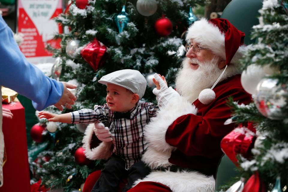 A young boy is ready to return to mom after taking a photo with Santa at the Dartmouth Mall.