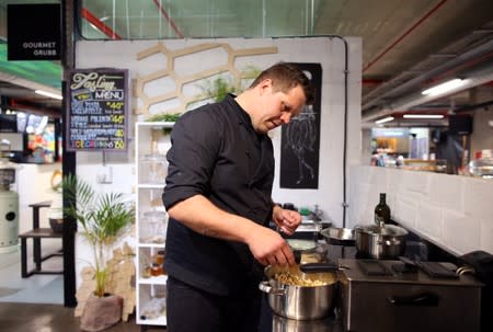 Chef Mario Barnard sprinkles Mopane worm spices on freshly made popcorn at the Insect Experience Restaurant in Cape Town, South Africa