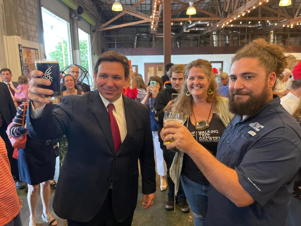 Florida Gov. Ron DeSantis visits with Mike and Brooke Malone, co-owners of Walking Tree Brewery in Vero Beach, on Monday, Feb. 28, 2022.