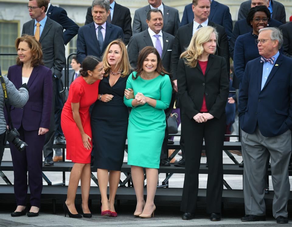 Then newly-elected House Members Alexandria Ocasio-Cortez, D-NY, left, and Debbie Mucarsel-Powell (D-FL), center, and Abby Finkenauer, D-IA, right, huddle from the wind and cold as they arrive to gather at the U.S. Capitol for a class photo. -- Photo by Jack Gruber, USA TODAY Staff ORG XMIT: JG 137631 Congress photo 11/14/2018 (Via OlyDrop)