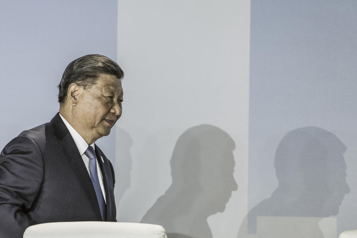 Chinese President Xi Jinping walks across a stage.