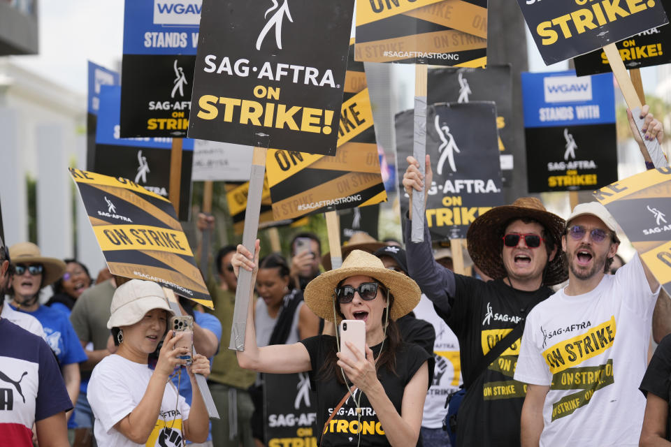 File - People picketing on behalf of the Screen Actors Guild-American Federation of Television and Radio Artists carry signs outside Netflix on Sept. 27, 2023, in Los Angeles. From auto production lines to Hollywood, the power of labor unions is back in the national spotlight. (AP Photo/Chris Pizzello, File)