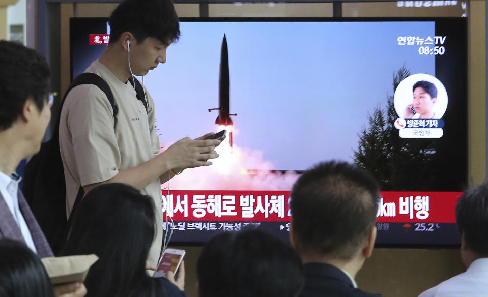 People watch a TV showing a file image of North Korea's missile launch during a news program at the Seoul Railway Station in Seoul, South Korea, Thursday, July 25, 2019. North Korea fired two unidentified projectiles into the sea on Thursday, South Korea's military said, the first launches in more than two months as North Korean and U.S. officials work to restart nuclear diplomacy. The signs read: "North Korea fired unidentified projectiles into the sea." (AP Photo/Ahn Young-joon)