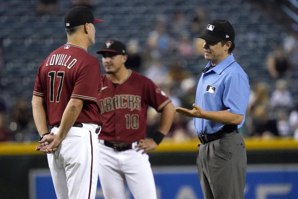 Arizona Diamondbacks manager Torey Lovullo (17) discuses a call with umpire D.J. Reyburn during the fifth inning of a baseball game against the Milwaukee Brewers, Wednesday, June 23, 2021, in Phoenix. (AP Photo/Matt York)