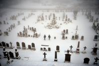 STIRLING, UNITED KINGDOM - DECEMBER 03: Two men walk through Stirling Castle graveyard on December 3, 2012 in Stirling, Scotland. Snow and sleet has hit many parts of Scotland with heavier falls expected over higher grounds. (Photo by Jeff J Mitchell/Getty Images)