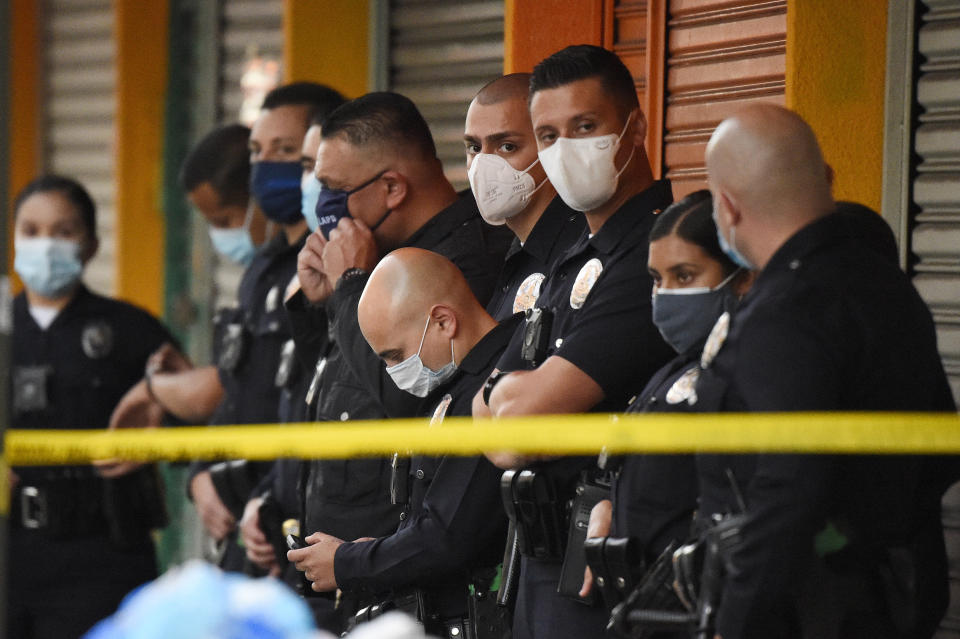 Los Angeles Police Department officers stand at the scene of a structure fire that injured multiple firefighters, according to a fire department spokesman, Saturday, May 16, 2020, in Los Angeles. (AP Photo/Mark J. Terrill)