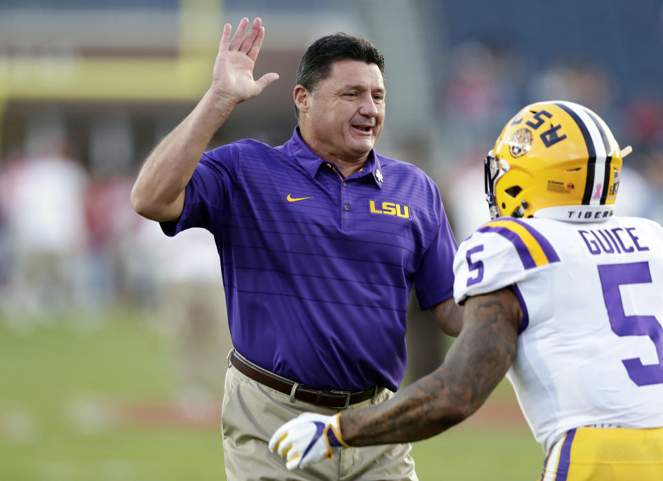 LSU head coach Ed Orgeron prepares to "high five" running back Derrius Guice (5) during pregame warmups of an NCAA college football game against Mississippi in Oxford, Miss., Saturday, Oct. 21, 2017. No. 24 LSU won 40-24. (AP Photo/Rogelio V. Solis)