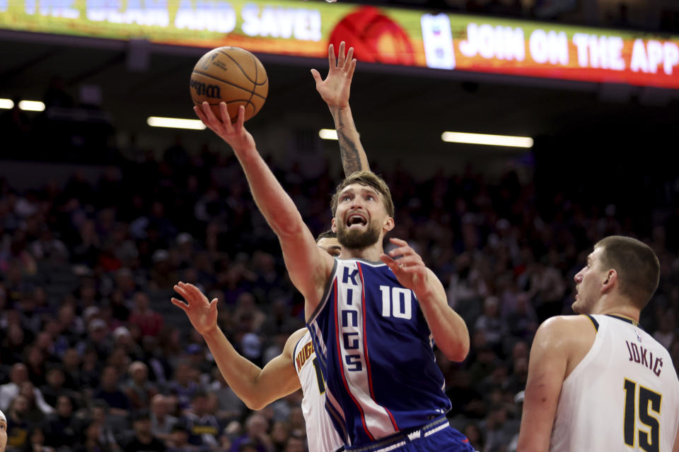 Sacramento Kings forward Domantas Sabonis (10) shoots against Denver Nuggets center Nikola Jokic (15) during the second half of an NBA basketball game in Sacramento, Calif, Saturday, Dec. 2, 2023. (AP Photo/Jed Jacobsohn)