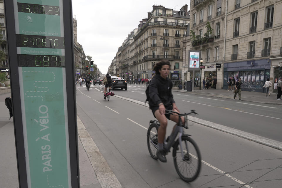 A man rides past a bicycle counter in Paris, Wednesday, Sept. 13, 2023. Years of efforts to turn car-congested Paris into a more bike-friendly city are paying off ahead of the 2024 Olympics, with increasing numbers of people using the French capital's growing network of cycle lanes. (AP Photo/John Leicester)