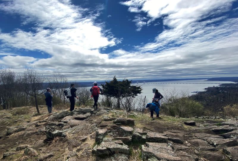Hikers practice social distancing as they stand on trail above Hudson River in Hook Mountain State Park in Nyack, New York