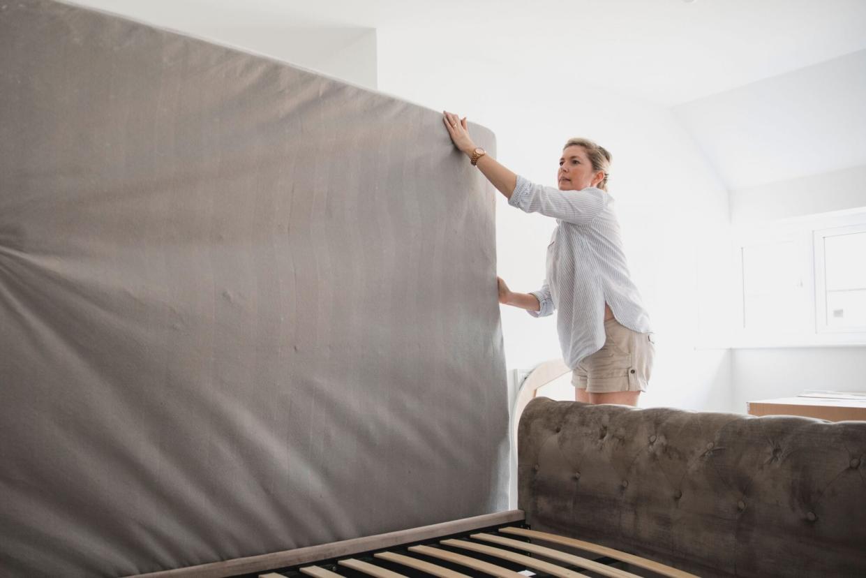 woman moving old mattress