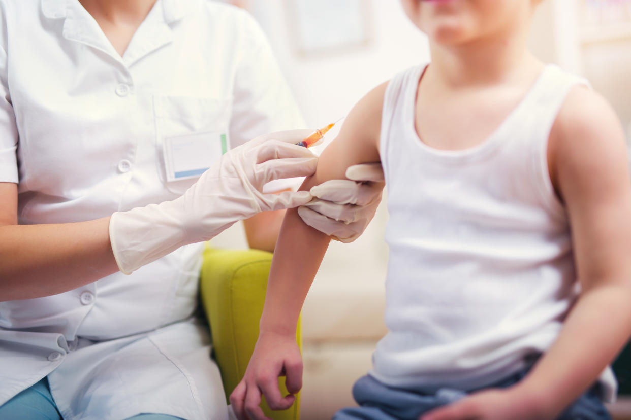 Pediatrician gives vaccination to a young boy. (Photo via Getty Images/Jovanmandic)