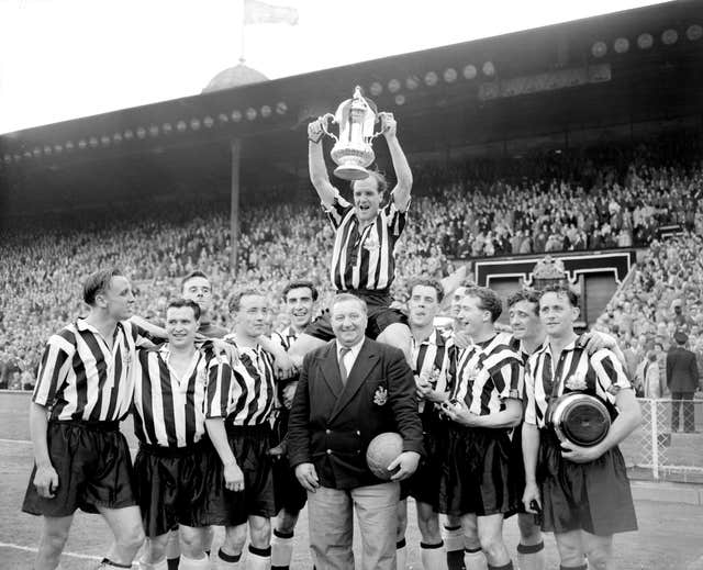 Newcastle captain Jimmy Scoular lifts the FA Cup aloft after a 3-1 victory over Manchester City in the 1955 final 