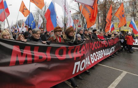 People attend a rally in memory of Russian opposition politician Boris Nemtsov, who was assassinated in 2015, in Moscow, Russia February 24, 2019. The banner reads "We gave Nemtsov's Russia away. It's time to bring it back!" REUTERS/Maxim Shemetov