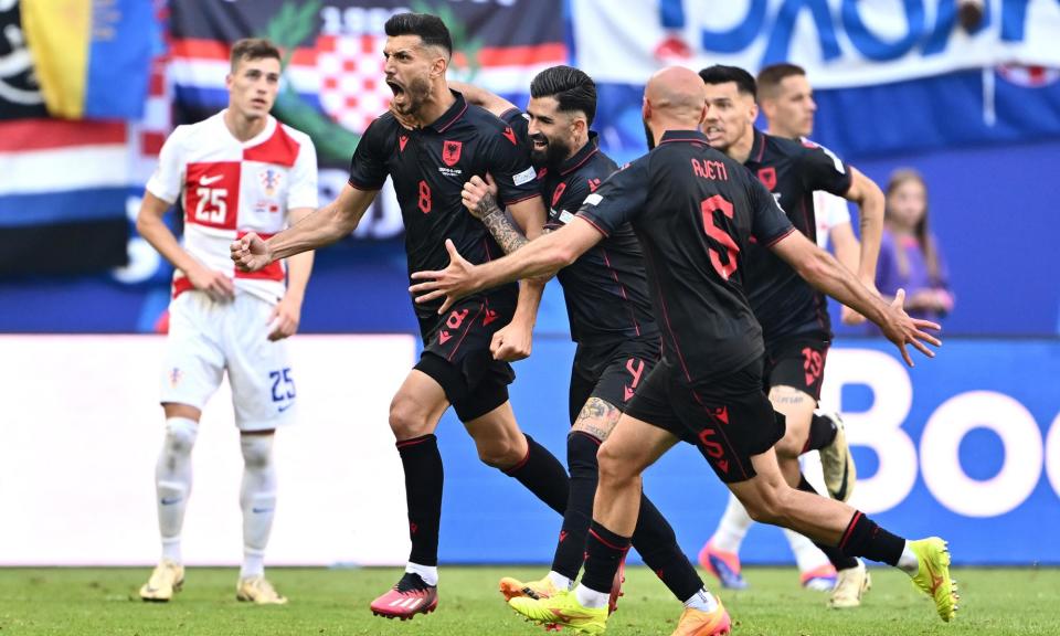<span>Klaus Gjasula (left) leads Albania’s wild celebrations after cancelling out his own goal with a late equaliser.</span><span>Photograph: Dan Mullan/Getty Images</span>
