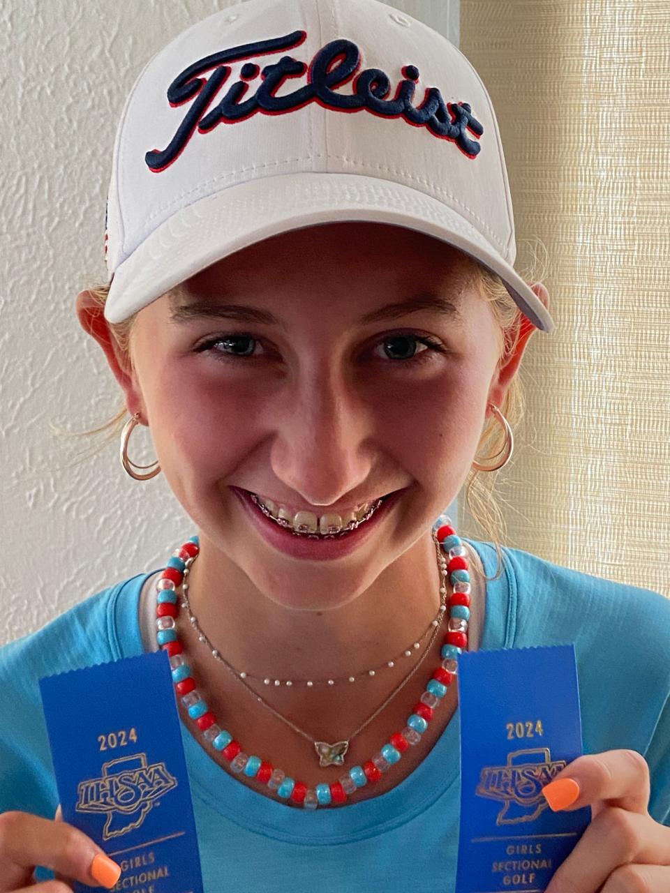 La estudiante de primer año Lucy Dunham muestra las dos cintas de primer lugar que recibió el viernes en Knollwood Country Club después de la sección de golf femenino de la IHSAA. Su 79, siete sobre par, le valió los honores de medallista y llevó a los Huskies a una victoria de dos golpes sobre el anfitrión Penn por el título general por equipos.