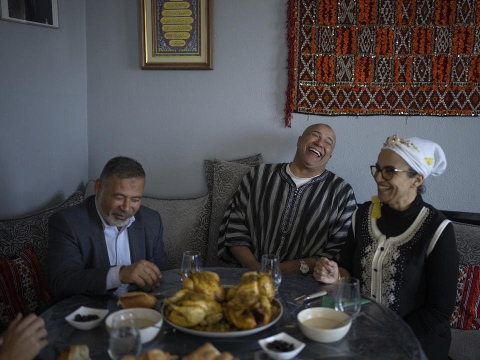 Majda Ould Ibbat, right, and her husband, Lhoussaine, center, share a meal with Imam Mohsen Ngazou, the founding director of the Ibn Khaldoun school, at their family home in Marseille, southern France, Sunday, April 21, 2024. Majda Ould Ibbat was considering leaving Marseille until she discovered Ibn Khaldoun, where her children could both freely live their faith and flourish academically. (AP Photo/Daniel Cole)