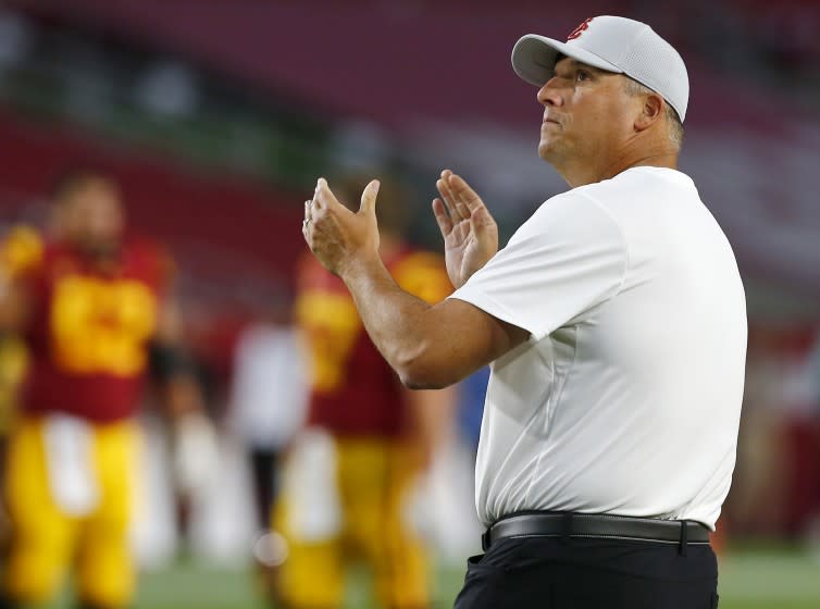 USC coach Clay Helton watches his team warm up before a game against Stanford at the Coliseum on Sept. 7.