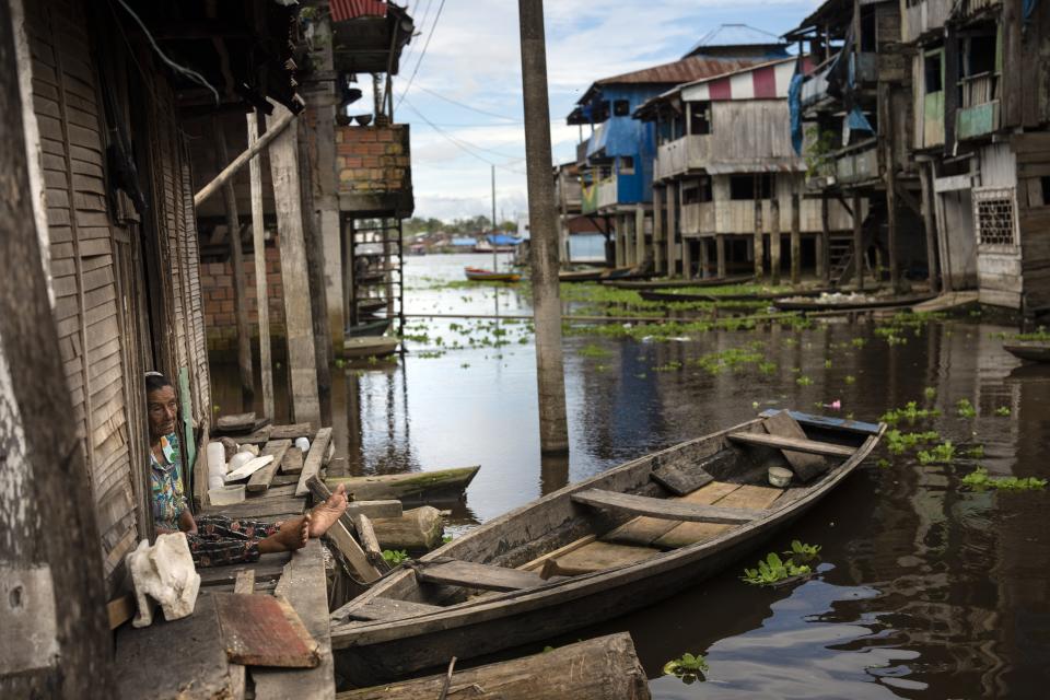 Una mujer sentada en la puerta de su casa en el barrio Belén de Iquitos, Perú, el sábado 25 de mayo de 2024. La comunidad indígena en el corazón de la Amazonía peruana conocida como la "Venecia de la Selva" organiza el Festival de Cine Flotante Muyuna, para celebrar los bosques tropicales. (Foto AP/Rodrigo Abd)