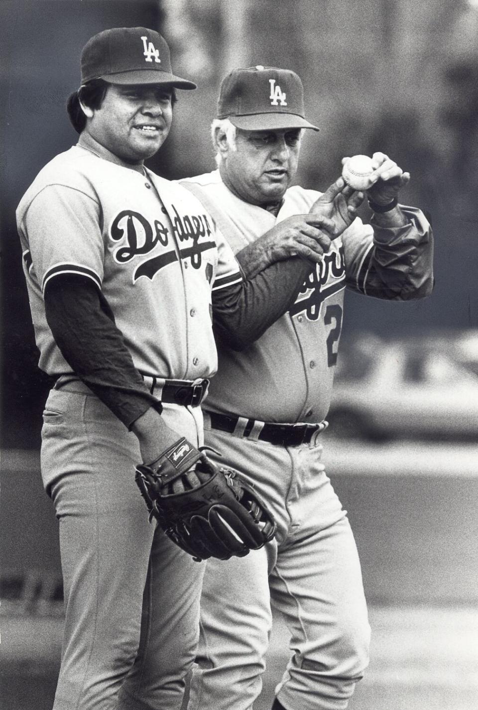 Tom Lasorda holds a baseball with Fernando Valenzuela