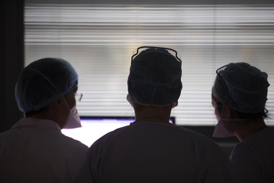 Medical staff members speak in the intensive care unit of the Strasbourg University Hospital, eastern France, Thursday Jan. 13, 2022. The omicron variant is exposing weaknesses at the heart of Europe's public health system. In France and Britain, a sharp rise in coronavirus hospitalizations coupled with staff falling sick has led to a shortage of beds. (AP Photo/Jean-Francois Badias)