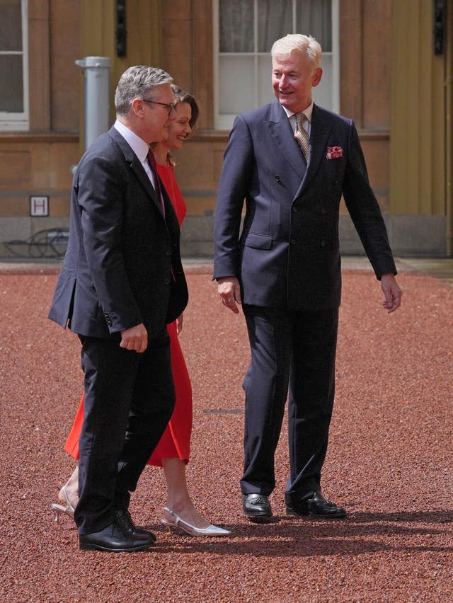 Sir Clive Alderton, principal private secretary to the King and Queen, greets Sir Keir Starmer and his wife Victoria at Buckingham Palace