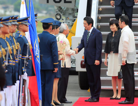 Japanese Prime Minister Shinzo Abe is greeted by Philippine Foreign Secretary Perfecto Yasay upon arrival for a state visit in metro Manila, Philippines January 12, 2017. Pictured second right is Prime Minister Shinzo Abe's wife Akie Abe. REUTERS/Romeo Ranoco