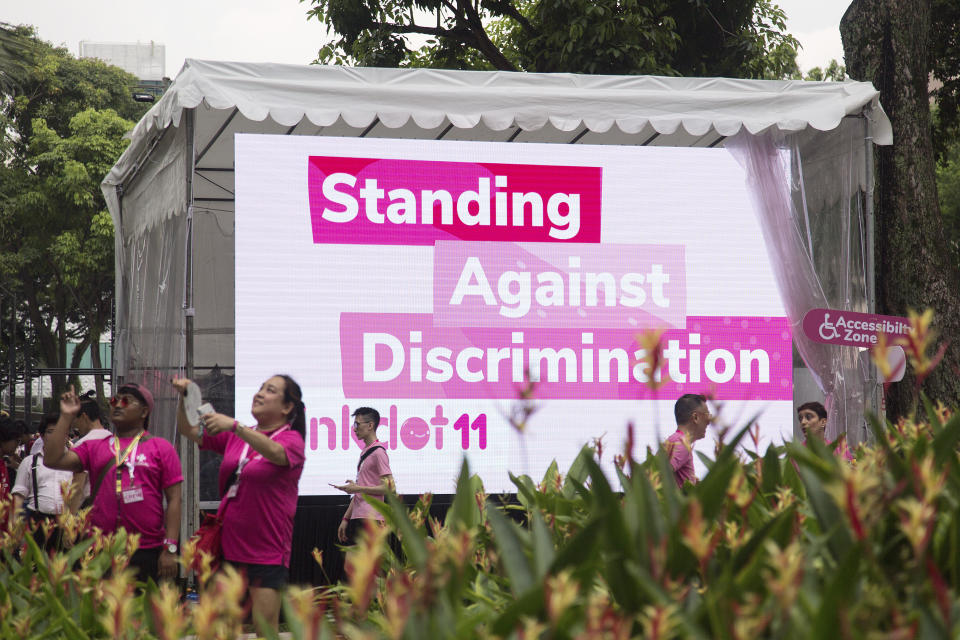 Attendees and volunteers walk past a banner during the Pink Dot event held at the Speaker's Corner in Hong Lim Park on 29 June, 2019. (PHOTO: Getty Images)