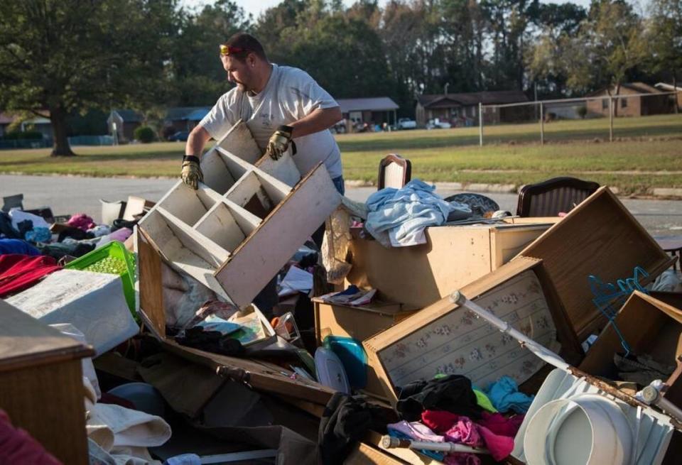Andrew Richardson of Fayetteville looks for salvageable furniture in a pile of debris outside a gutted home Tuesday, Nov. 15, 2016 in Lumberton, one of the most heavily flooded areas in N.C. following Hurricane Matthew.