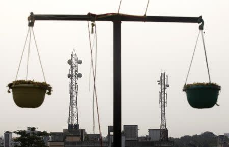 Telecommunication towers are pictured through hanging flower pots at a residential building in Kolkata December 11, 2012. Bharti Infratel Ltd, the telecommunications tower arm of top Indian mobile carrier Bharti Airtel, said it will allot shares worth $120 million to cornerstone investors as part of its up to $832 million initial public offering. REUTERS/Rupak De Chowdhuri (INDIA - Tags: BUSINESS TELECOMS)