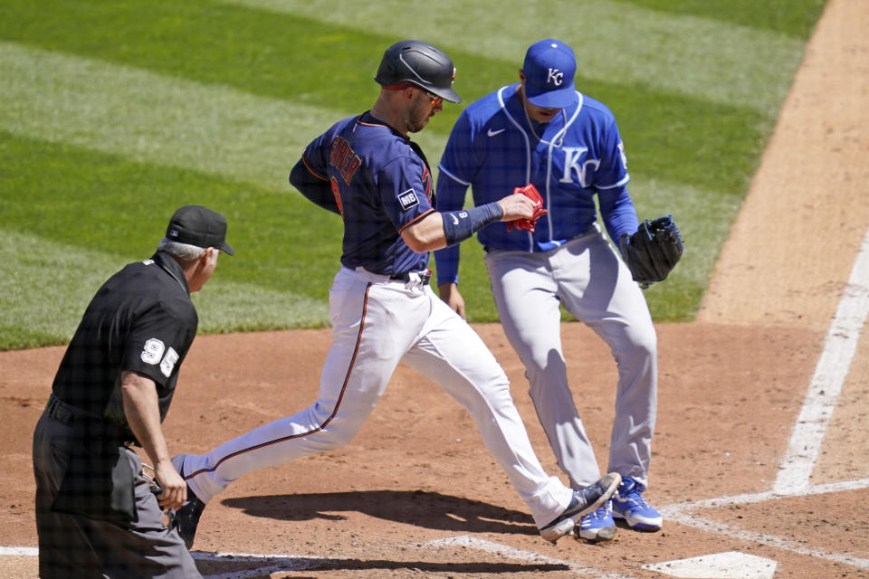 Minnesota Twins' Mitch Garver, center left, scores on a passed ball off Kansas City Royals pitcher Carlos Hernandez, right, in the fourth inning of a baseball game, Saturday, May 29, 2021, in Minneapolis. (AP Photo/Jim Mone)